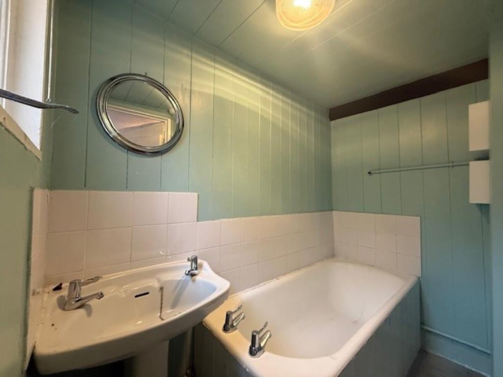 Lot: 115 - A PAIR OF THATCHED COTTAGES IN NEED OF IMPROVEMENT - 50 Abbey Street bathroom with bath and sink